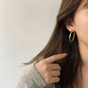 Elegant gold twisted hoop earrings for women with polished finish and minimalist style