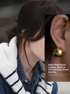 Macro view of golden irregular ball earrings with high mirror finish and 925 silver posts