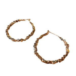 Golden geometric mosaic hoop earrings with a faceted textured surface and wavy edges