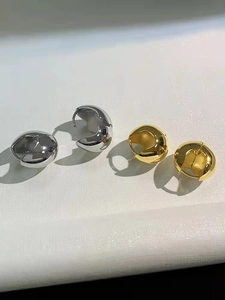 Macro view of chunky gold and silver hoop earrings with polished mirror finish