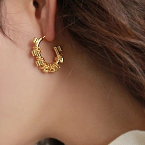 Golden C-shaped earrings with spiral twisted texture in vintage geometric metal style