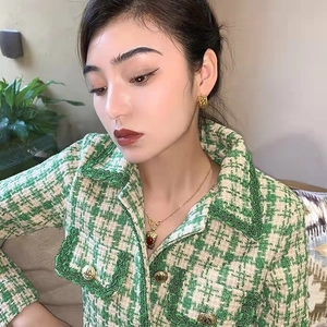 Classic woven pattern gold C-shape hoop earrings styled with a green tweed jacket