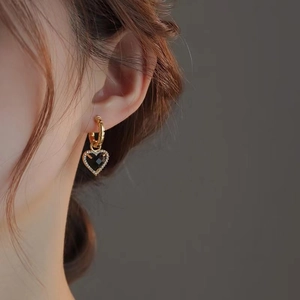 Orecchini a cuore retrò neri e oro con cristalli indossati dalla modella