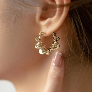 Gros plan sur l'élégante boucle d'oreille créole torsadée en métal doré poli