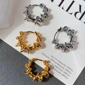 Boucles d'oreilles créoles torsadées en or et argent avec texture métallique géométrique