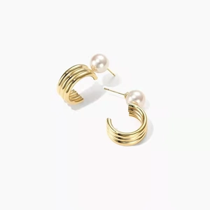 Elegant gold C-shaped metal earrings with parallel grooves and round white pearls