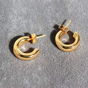 Chic gold-plated brass chunky hoop earrings with high-polish finish on a stone surface