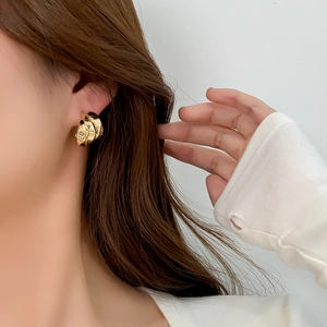 Detailed view of layered 14K brass earrings on model for an elegant metal look