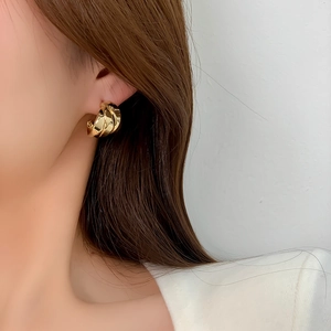 Close-up of 14K gold-plated chunky layered twisted C-shaped earrings on a model