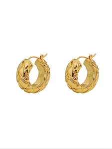 Detailed view of golden hoop earrings featuring a classic quilted geometric texture