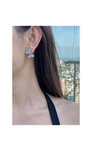 Close-up of a silver butterfly earring with micro-pave zircons worn by a model
