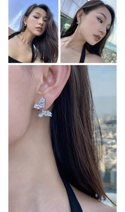 Detail view of silver butterfly earrings with sparkling cubic zirconia on a female model