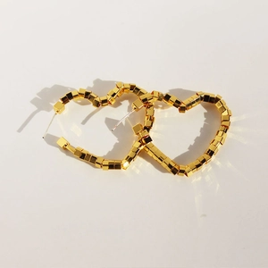 Golden heart-shaped stud earrings made of small geometric cubes in minimalist style