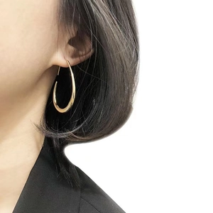 Elegant 14K gold plated brass teardrop hoop earrings for women shown on a model
