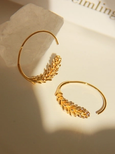 Macro detail of gold wheat ear earrings featuring intricate textures and 18K gold luster