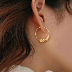 French style brass gold wheat ear geometric earrings worn by a model on a warm background