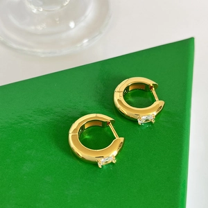 Gold plated brass hoop earrings with rectangular zircon on green geometric stand