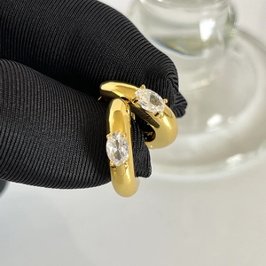Close-up of gold plated brass hoop earrings with claw-set oval cubic zirconia stones