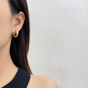 Polished gold plated hoop earring with pear cut zircon drop on female model