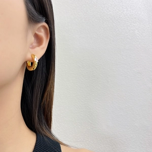 Close-up of gold-plated brass hoop earring featuring a brilliant centered zircon stone