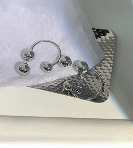 Macro view of polished S925 silver ball earrings with sleek metallic mirror finish