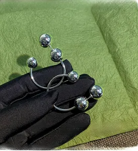 Macro detail of silver geometric ball earrings featuring a modern multi-sphere design