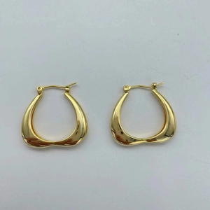 Macro shot of gold geometric earrings with a polished mirror finish and shiny metal texture