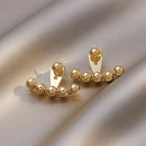 18K gold-plated brass fan-shaped stud earrings with tiered beads on silk background