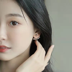 Detailed view of 18K gold-plated brass fan-shaped sphere stud earrings on a model