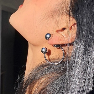 Minimalist silver spherical dual-wear earrings shown as worn on female model's ear