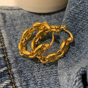 Golden pig nose link earrings on blue denim background featuring 925 silver stamp mark