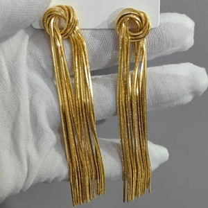 Detail of elegant gold tassel earrings featuring sleek snake chains and knot design