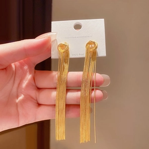 Close-up of golden tassel chain earrings with knot design and S925 silver needles
