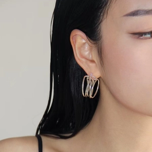Modern layered silver metal hoop earrings with a minimalist multi-circle interwoven design