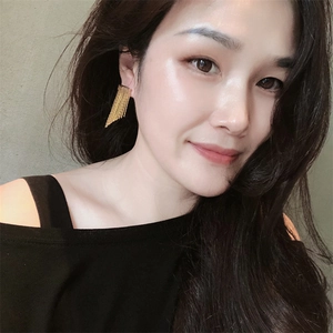 Elegant gold fringe chain tassel earrings with metallic luster on fashion model