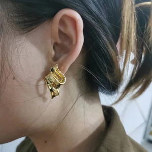 Fashionable 18K gold-plated earrings featuring a twisted ribbon abstract geometric design