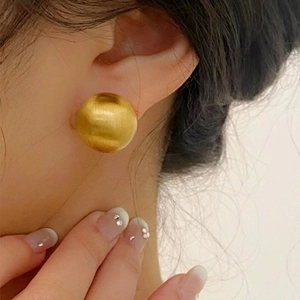 Minimalist matte gold ball earrings with brushed texture on model for stylish commute