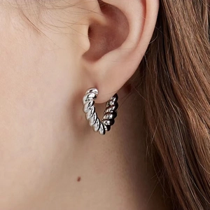 French vintage style silver twist croissant hoop earrings for women shown on model