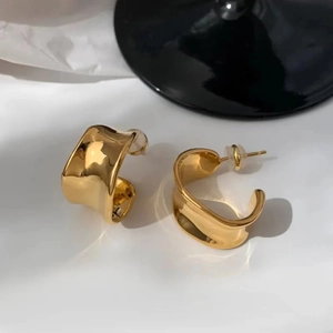 Polished gold irregular C-shape hoop earrings with fluid modern metallic design