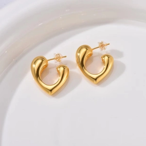 Detailed close-up of gold heart-shaped hoop earrings with secure silicone backs