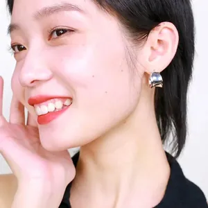Minimalist silver-plated C-shaped stud earrings shown on model with polished finish