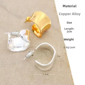Detailed view of U-shaped gold and silver earrings with 2cm x 1.6cm dimensions