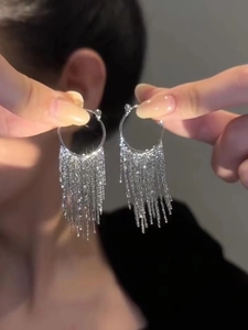 Macro shot of elegant silver tassel earrings featuring sparkling metallic fringe detail
