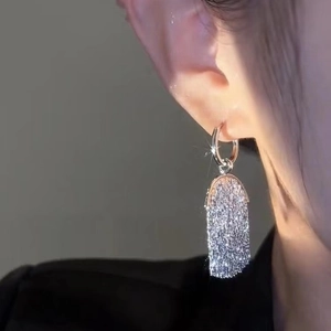 Elegant metal tassel earrings with shimmering rectangular pendants on a model