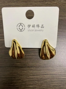 Detailed view of gold irregular teardrop earrings with textured wavy metal surface