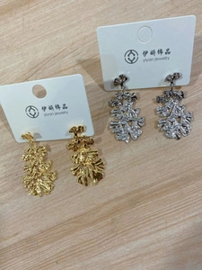 Detailed view of layered ginkgo leaf dangle earrings in gold and silver finishes