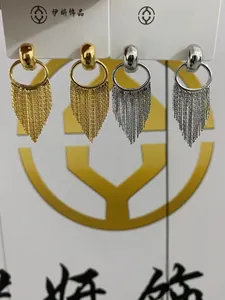 Detail of silver and gold tiered tassel drop earrings with triangular chain accents