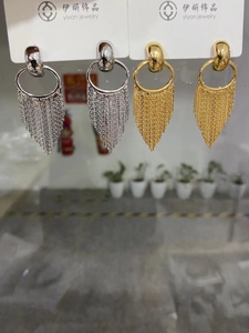 Detailed view of long statement tassel earrings in gold and silver metal finishes