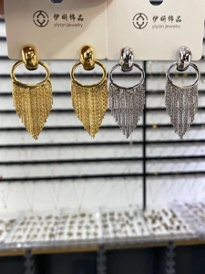 Close-up of gold and silver statement tassel earrings with layered metal fringe detail