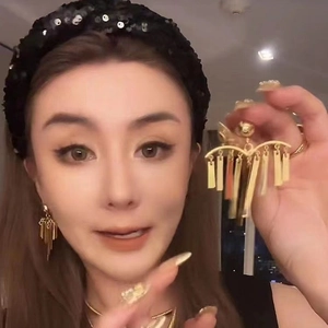 Elegant gold fringe tassel earrings featuring cascading pine needle metallic strips on model